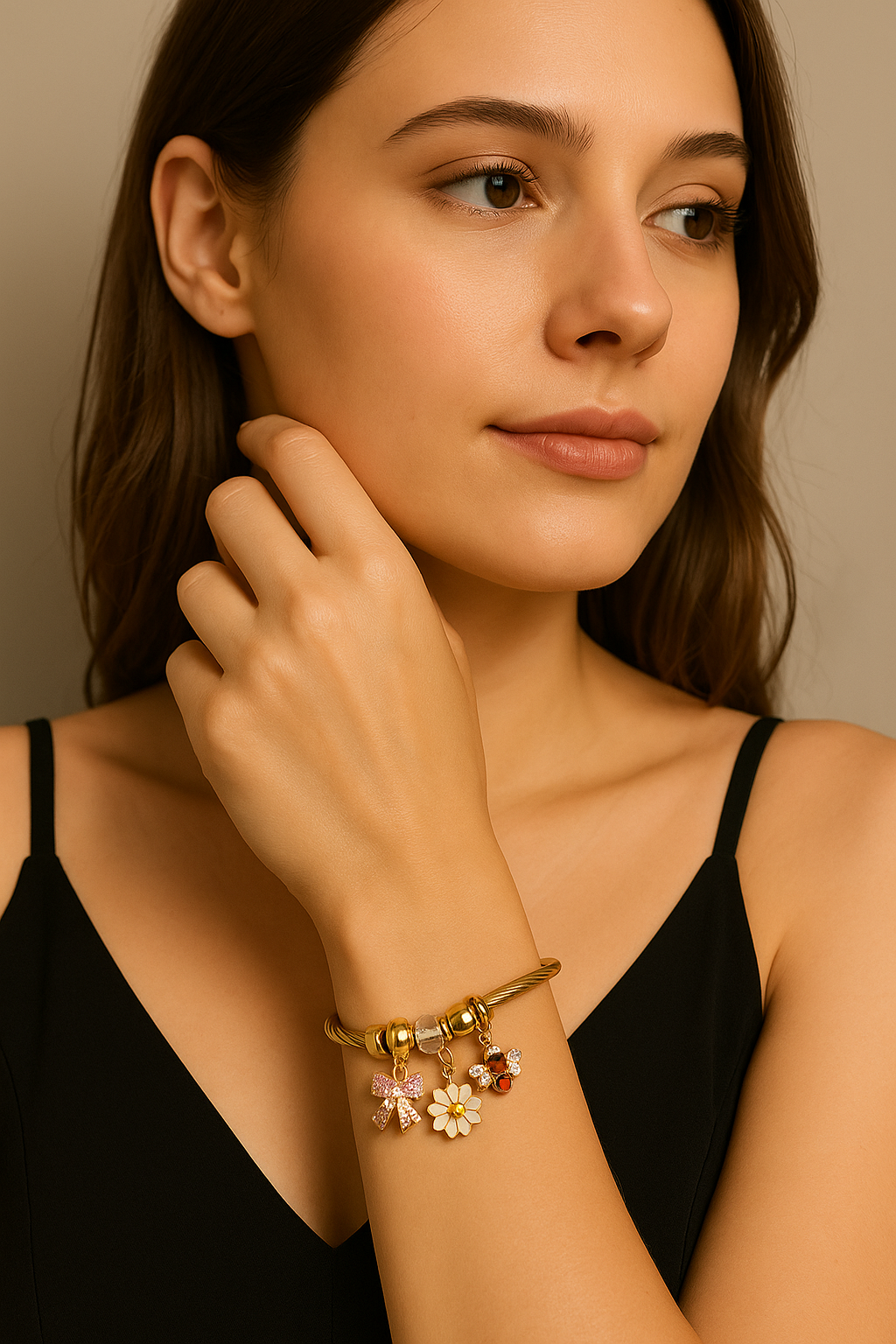 Gold bracelet with daisy, bee, and pink bow charms