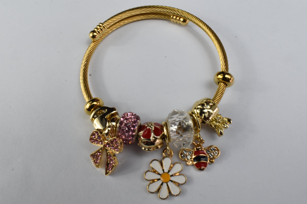 Gold bracelet with daisy, bee, and pink bow charms